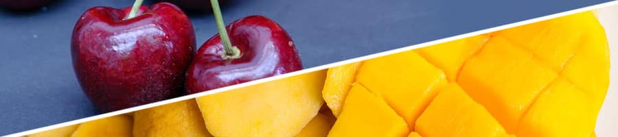 sliced mangoes on a plate, a couple of cherries on a table