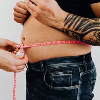 man using measuring tape for the stomach